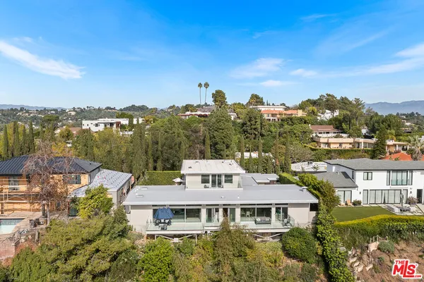 a aerial view of a house with a yard and balcony