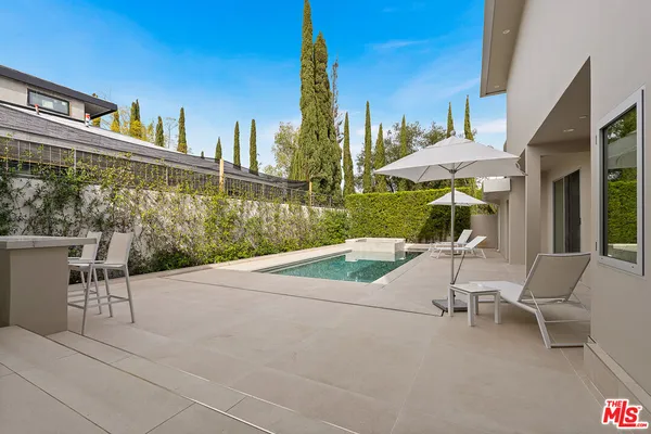 a view of a patio with a table and chairs under an umbrella