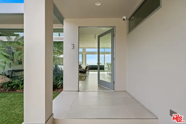 a view of a hallway with wooden floor and a living room