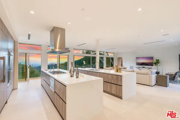 a large white kitchen with a large window and white cabinets