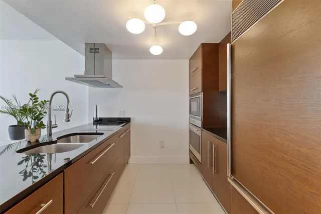 a kitchen with stainless steel appliances a sink and a refrigerator
