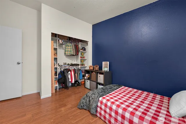 a bedroom with a bed and a wooden floor