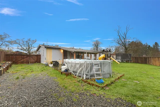 a view of a house with a yard deck and a tree