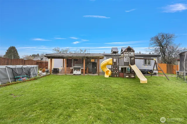 a view of a house with a yard and sitting area