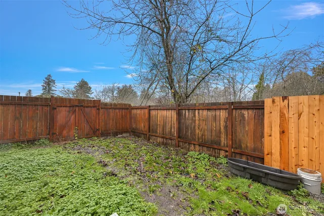 a view of a backyard with wooden fence