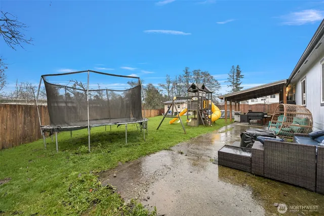 a view of a backyard with couches plants and wooden fence