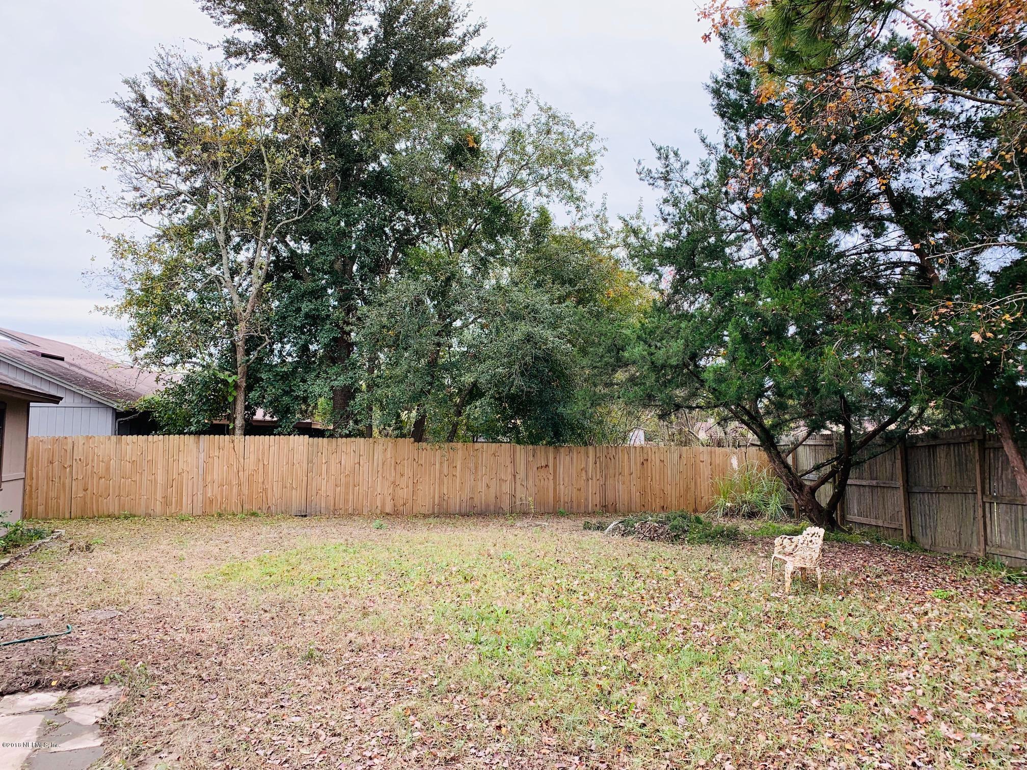 2526 Wattle Tree Road West Jacksonville, FL 32246 - Photo 19 of 19 a view of a backyard with large trees and wooden fence