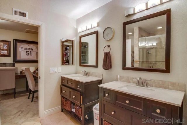 a bathroom with a double vanity sink and a mirror