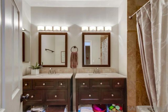 a bathroom with double vanity and a mirror