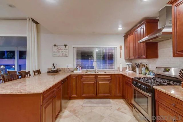 a kitchen with stainless steel appliances granite countertop a sink stove and cabinets