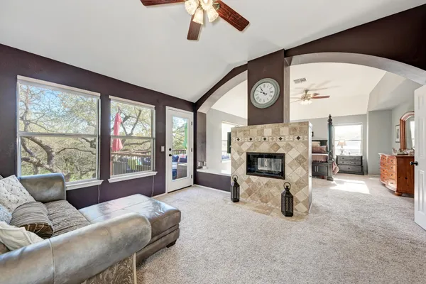 a living room with furniture a fireplace and a large window
