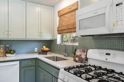 a kitchen with a stove a sink and a cabinets