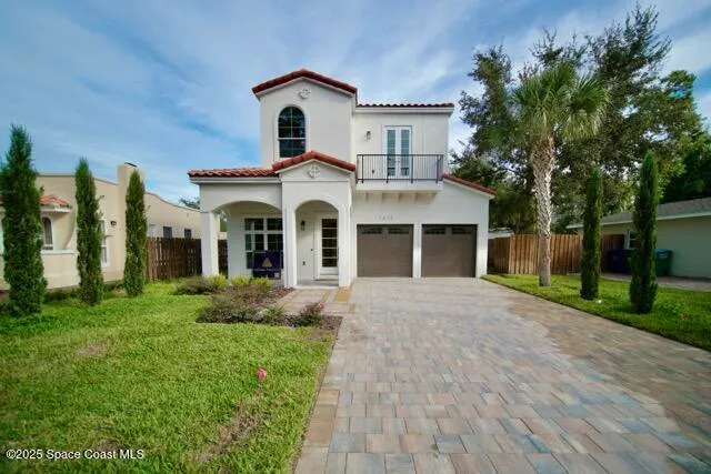 a front view of a house with a garden and trees