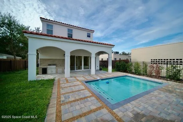 a backyard of a house with yard fire pit and wooden fence