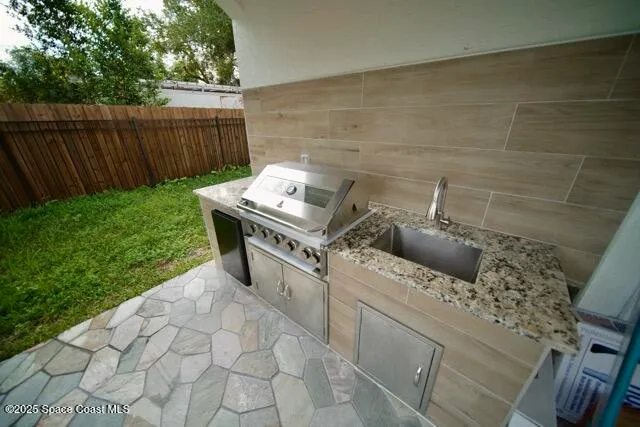 a large kitchen with stainless steel appliances a large counter top a refrigerator and a sink