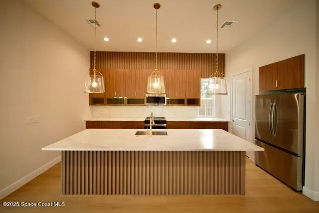 a kitchen with stainless steel appliances wooden cabinets a stove a sink and a microwave