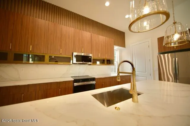 a kitchen with kitchen island a sink a counter top space appliances and cabinets