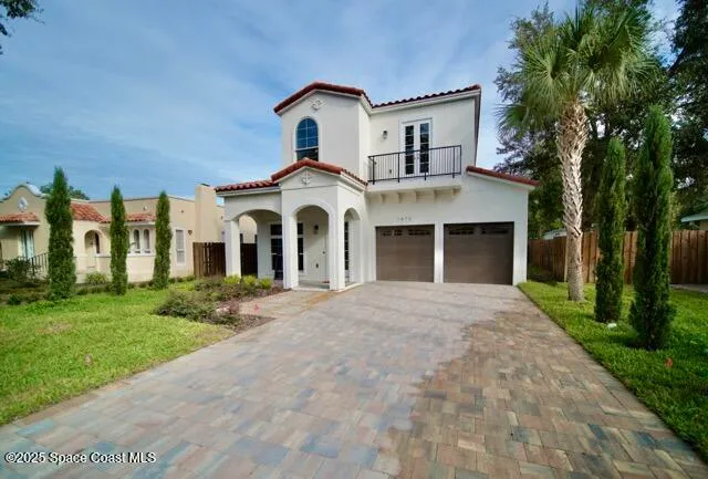 a front view of a house with a garden and trees