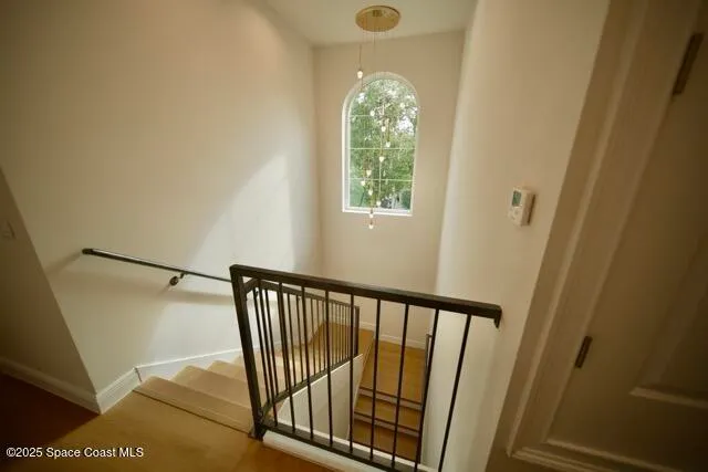 a view of a hallway with wooden floor and staircase