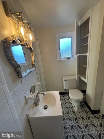 a bathroom with a toilet sink and mirror