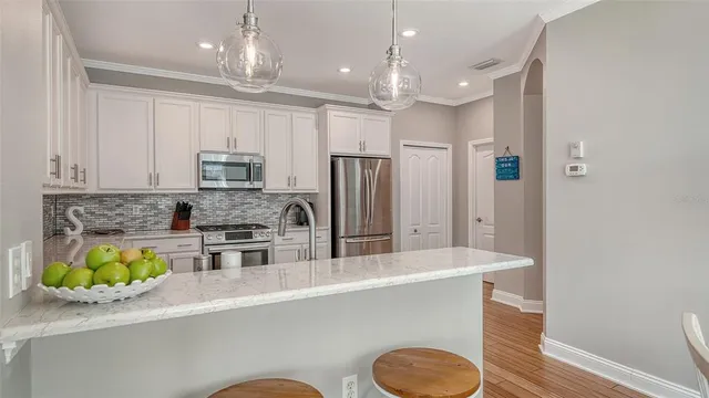 a kitchen with granite countertop a sink stainless steel appliances and wooden floor