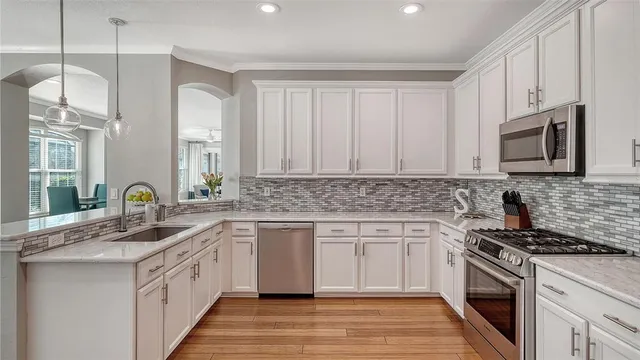 a kitchen with white cabinets and appliances