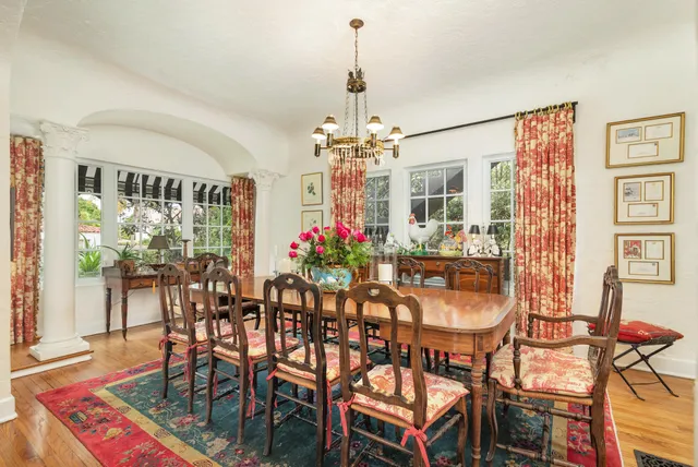 a dining room with furniture potted plants and wooden floor