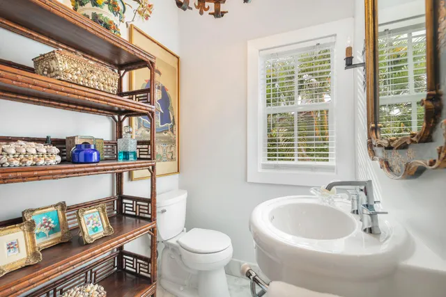 a bathroom with a sink a toilet and a window