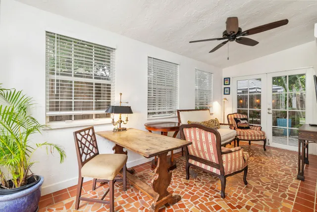 a living room with patio furniture and a potted plant