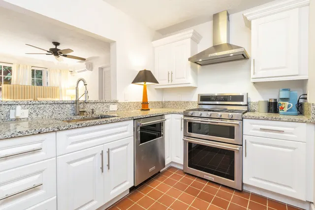 a kitchen with granite countertop white cabinets and white appliances