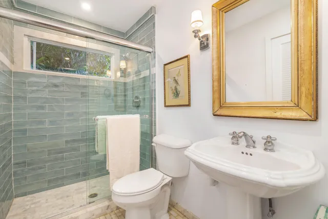 a bathroom with a sink a toilet and shower