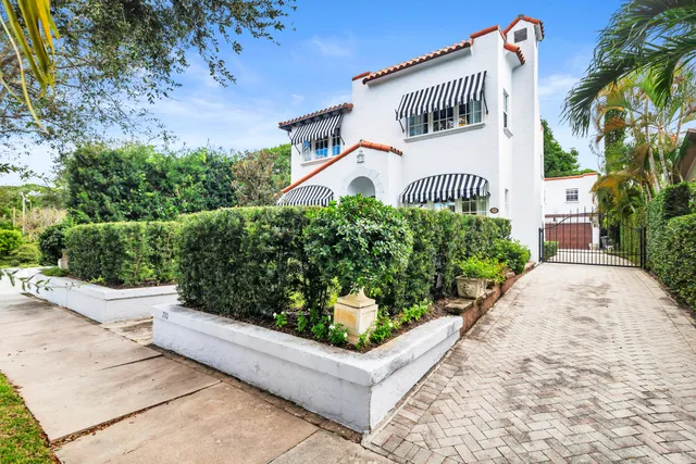 a front view of a house with a garden and plants
