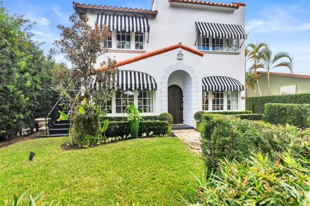 a front view of a house with a yard garden and deck
