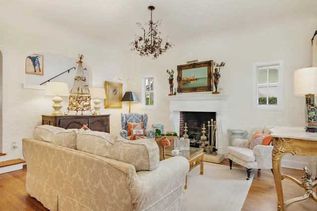 a living room with furniture a chandelier and a fireplace