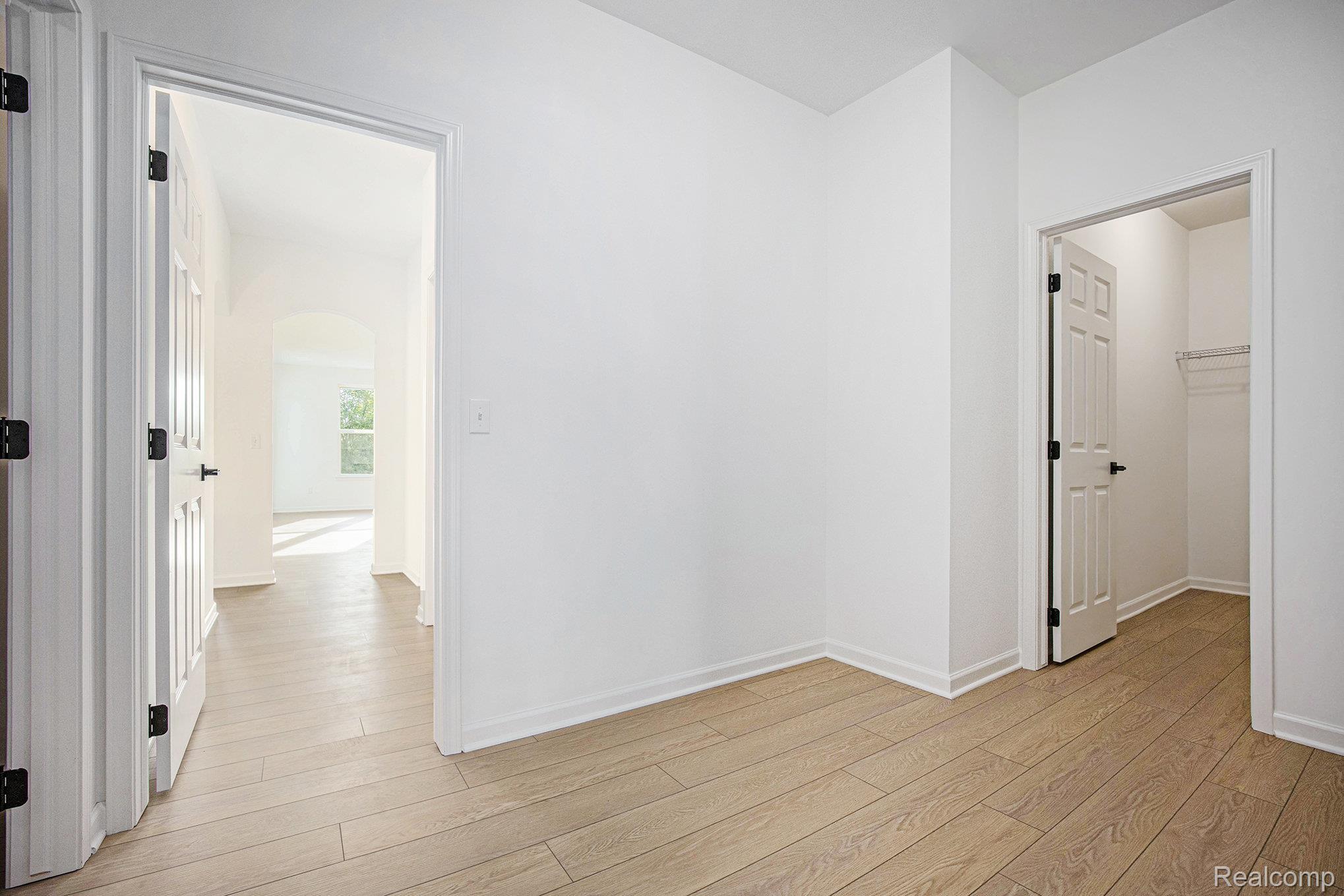 68788 Place Road New Haven, MI 48050 - Photo 25 of 29 Empty room featuring arched walkways and light wood-style flooring