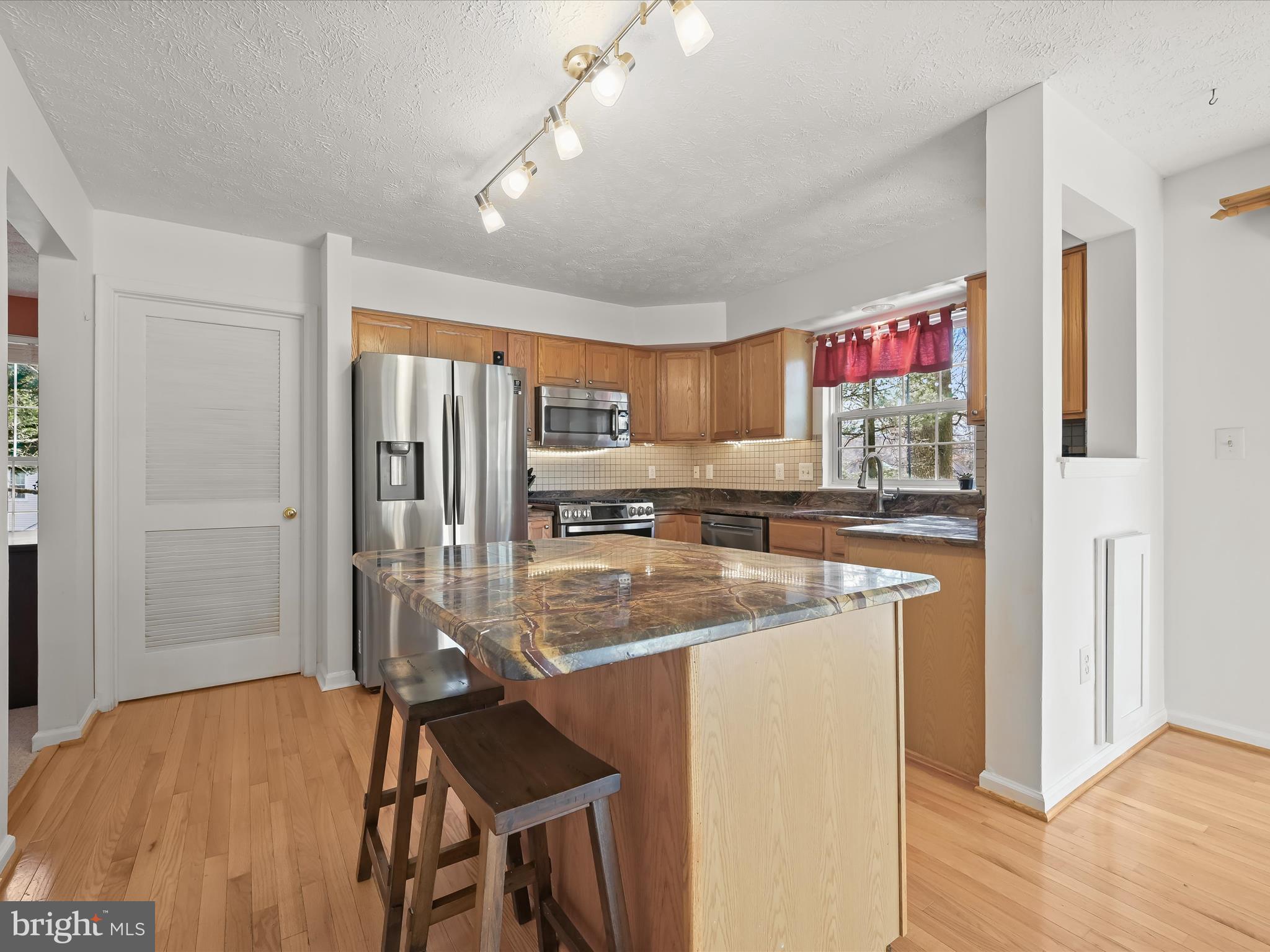 2333 Golden Chapel Road Odenton, MD 21113 - Photo 13 of 62 a kitchen with stainless steel appliances granite countertop a refrigerator a stove and a sink with wooden floor
