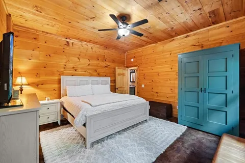 a bedroom with a bed and large windows