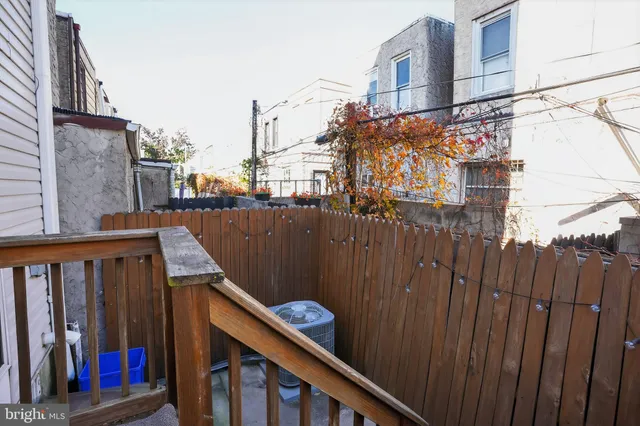 a view of a house with a small yard and wooden fence