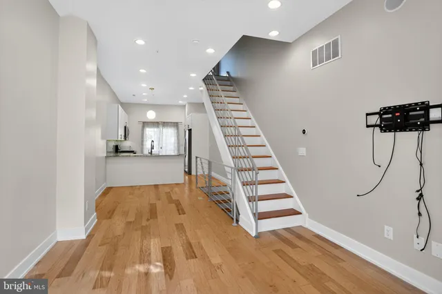 a view of a kitchen with wooden floor and stairs