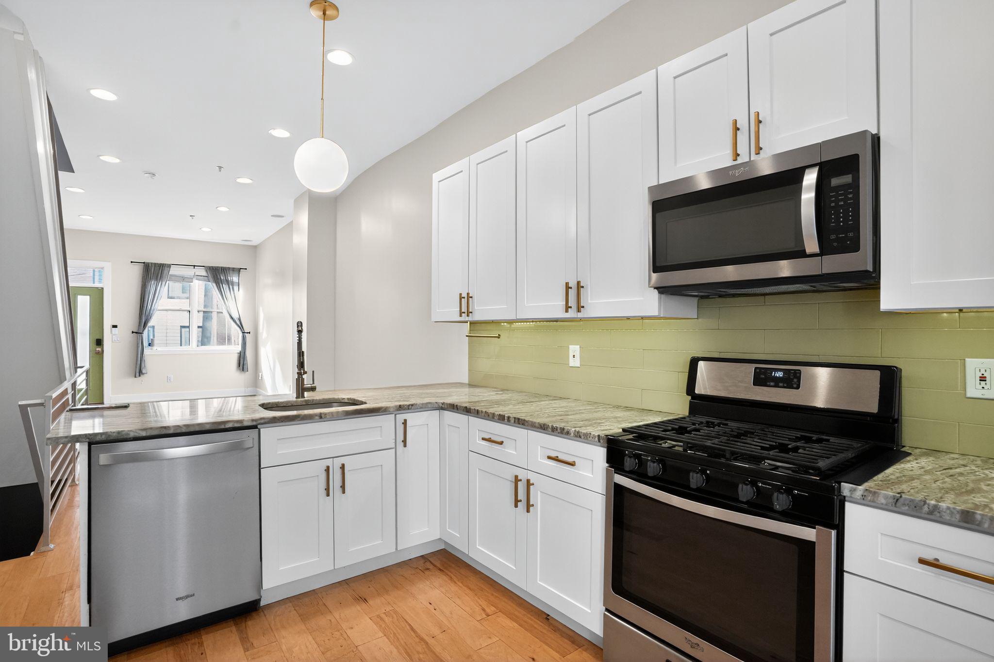419 Emily Street Philadelphia, PA 19148 - Photo 9 of 34 a kitchen with stainless steel appliances white cabinets granite counter tops and a stove