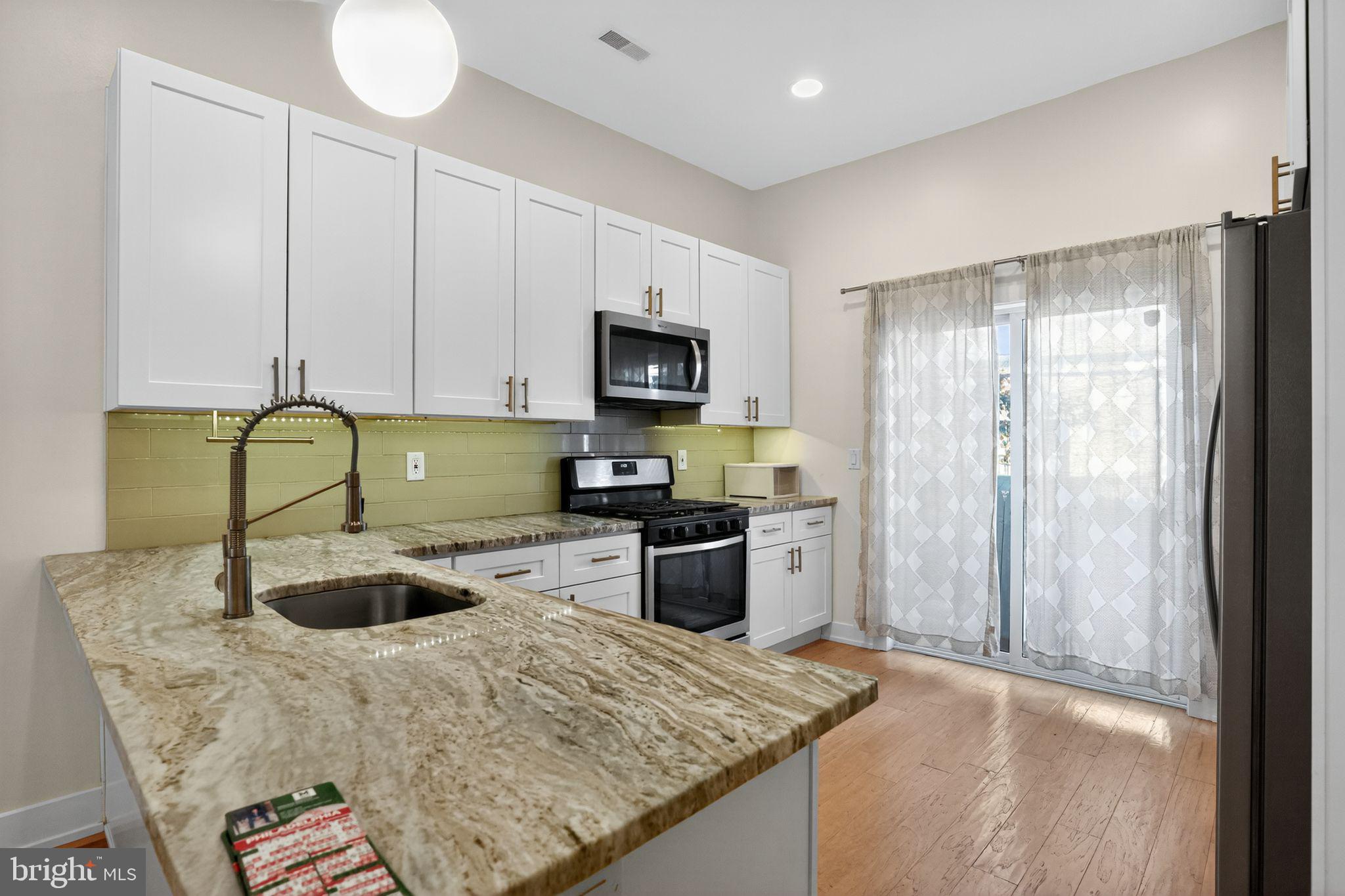 419 Emily Street Philadelphia, PA 19148 - Photo 10 of 34 a kitchen with a refrigerator and a stove top oven