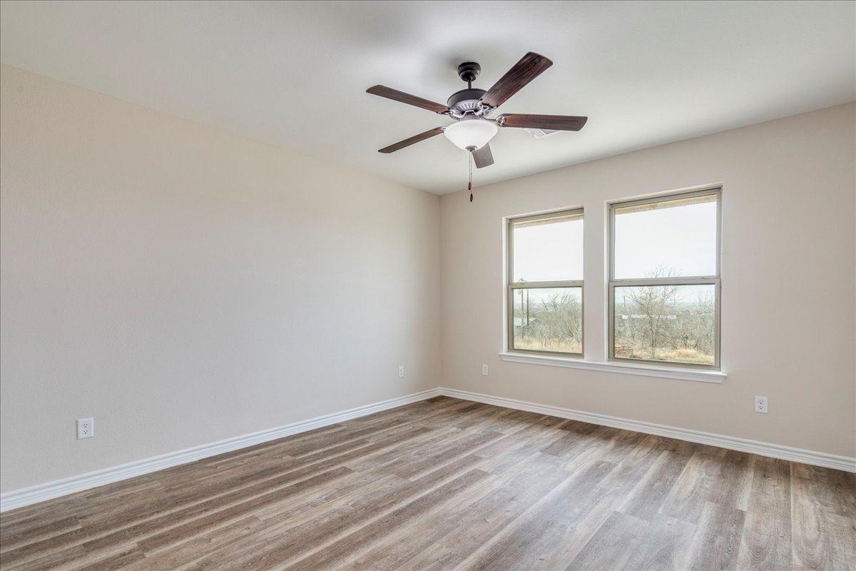 1092 Engelke Road Niederwald, TX 78640 - Photo 11 of 24 an empty room with wooden floor fan and windows