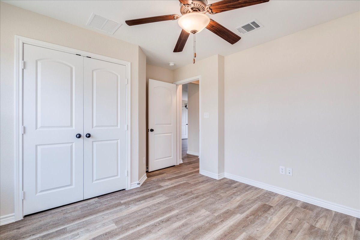 1092 Engelke Road Niederwald, TX 78640 - Photo 16 of 24 an empty room with wooden floor closet and fan
