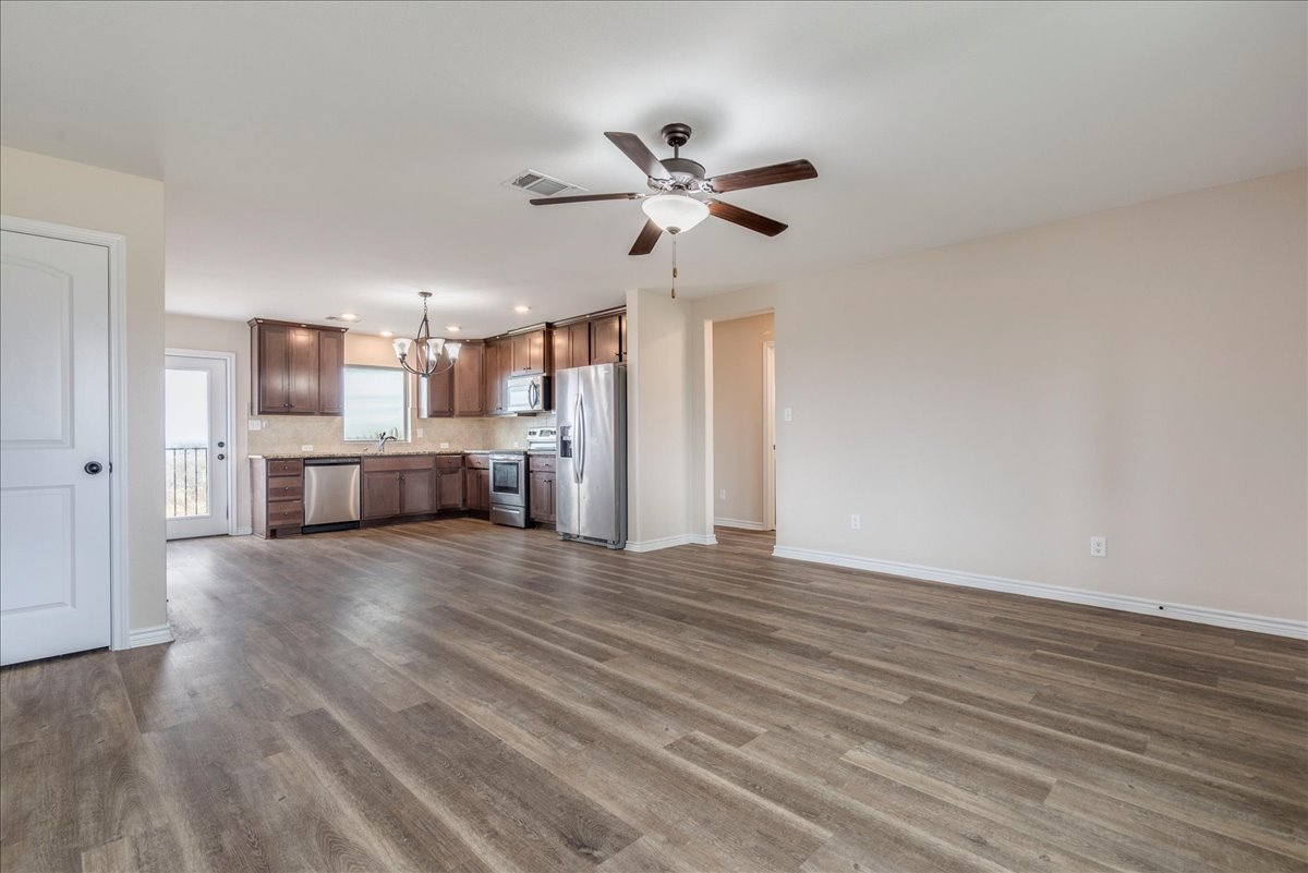 1092 Engelke Road Niederwald, TX 78640 - Photo 5 of 24 a view of a kitchen with a stove cabinets and wooden floor