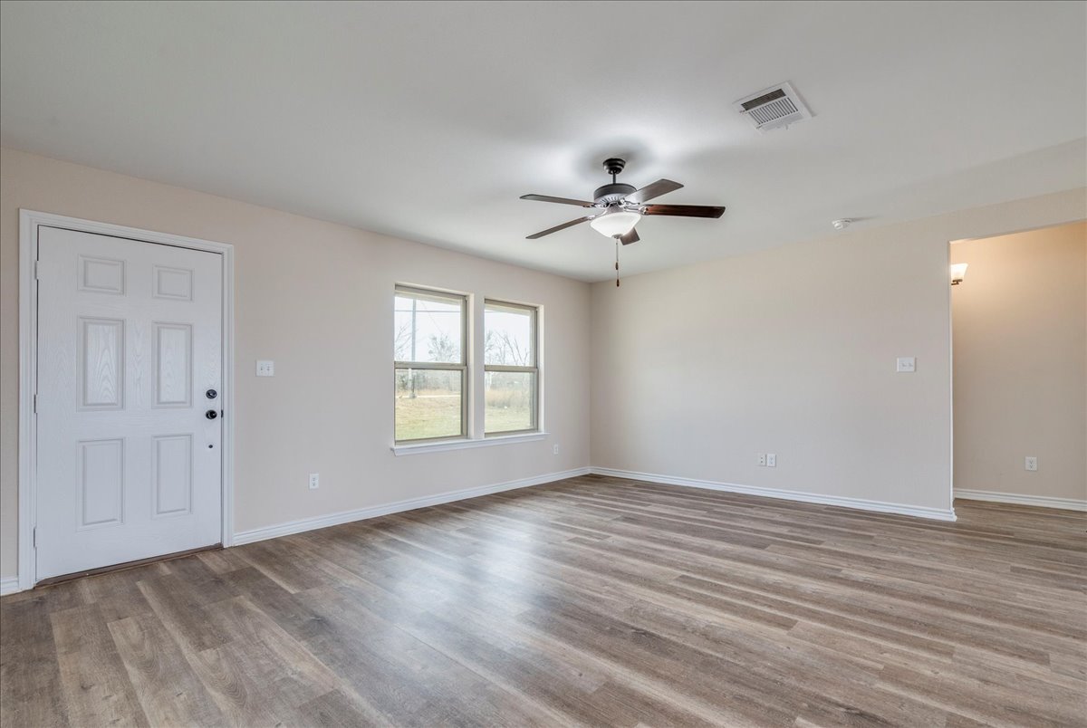1092 Engelke Road Niederwald, TX 78640 - Photo 7 of 24 a view of an empty room with a window and wooden floor