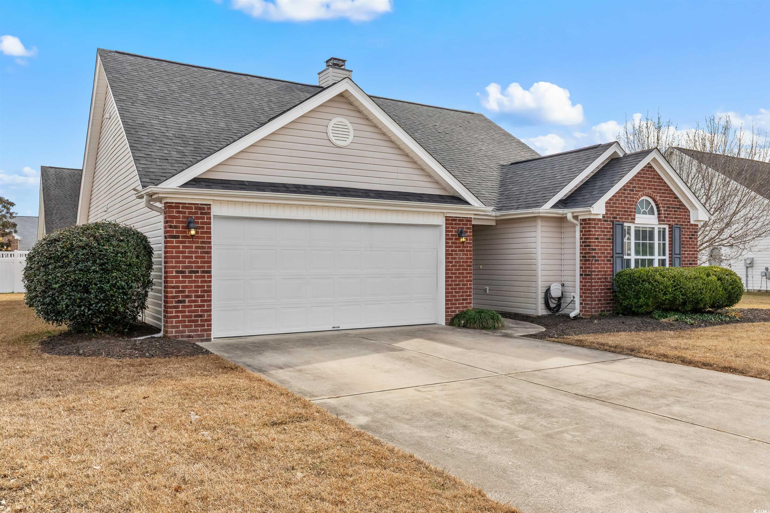 5029 Capulet Circle Myrtle Beach, SC 29588 - Photo 1 of 22 View of front of property with brick siding, driveway, a shingled roof, an attached garage, and a chimney
