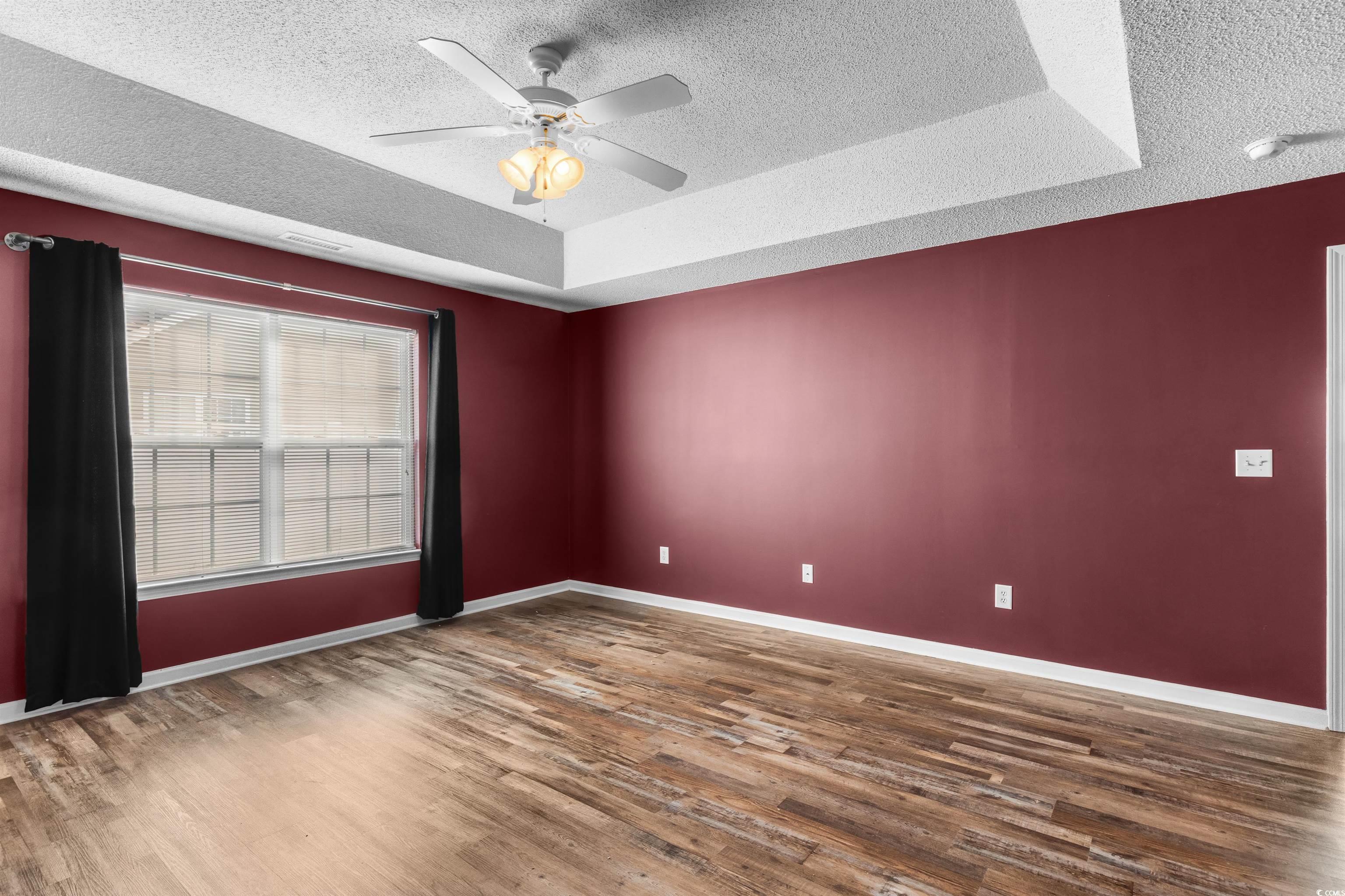 5029 Capulet Circle Myrtle Beach, SC 29588 - Photo 17 of 22 Empty room with a tray ceiling, a textured ceiling, ceiling fan, and wood finished floors