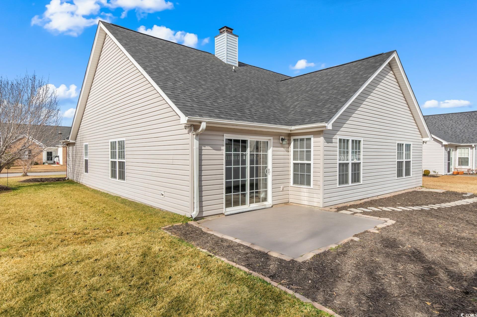 5029 Capulet Circle Myrtle Beach, SC 29588 - Photo 22 of 22 Rear view of property featuring a patio, a shingled roof, a yard, and a chimney