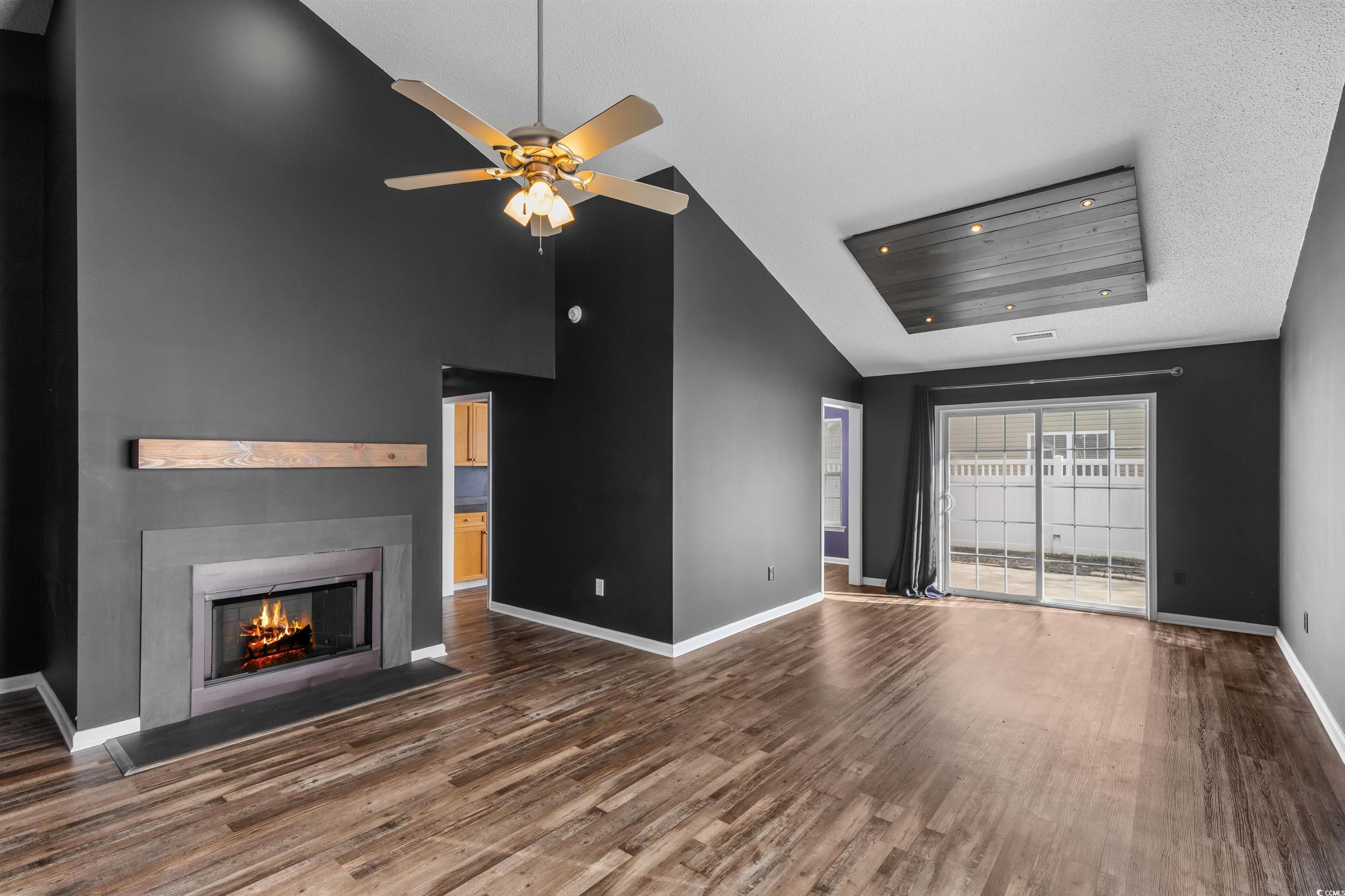 5029 Capulet Circle Myrtle Beach, SC 29588 - Photo 8 of 22 Unfurnished living room featuring a fireplace with flush hearth, ceiling fan, dark wood-type flooring, and high vaulted ceiling