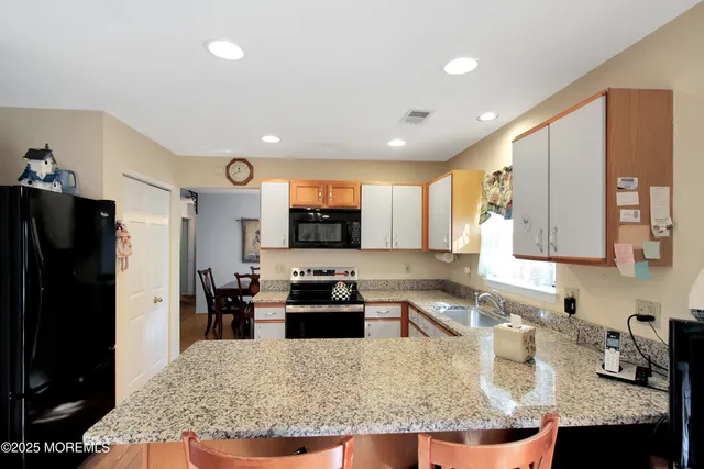 a kitchen with granite countertop lots of counter top space refrigerator and furniture